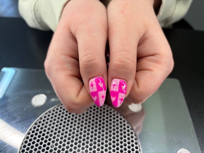 Pink almond nails with checkerboard hearts